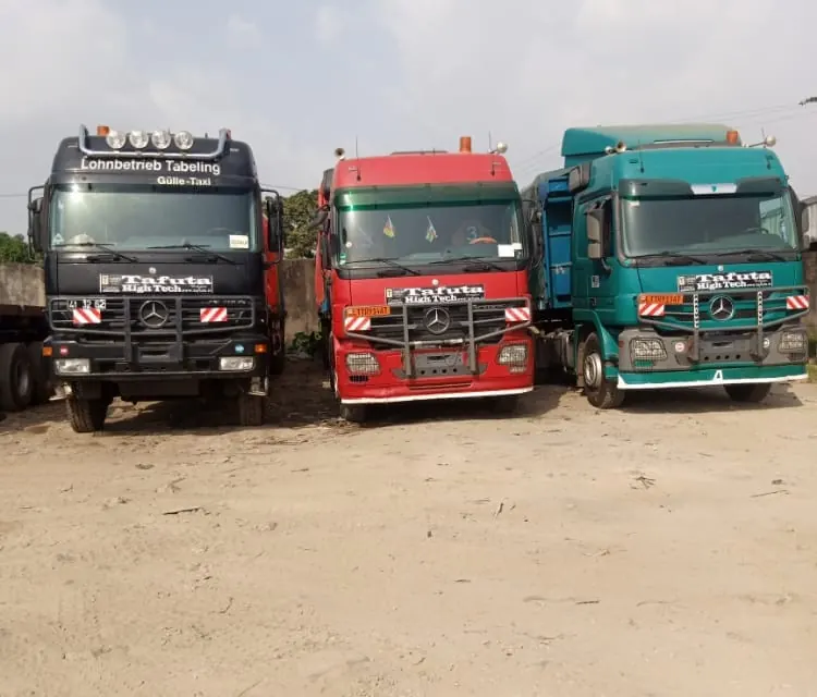 Three Mercedes Actros tractor units from a partner carrier lined up in a yard in Cameroon